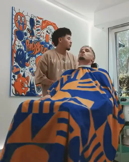 Michaël Cuisance au studio, sous la cape, pendant que Phily le coupe.